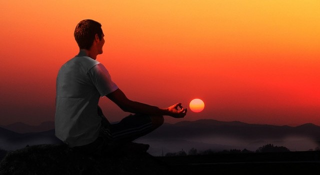 guy.meditating.sunset